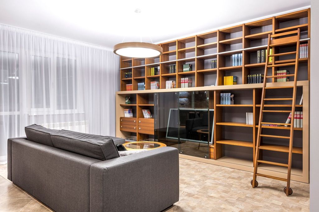 Bibliothèque sur toute la hauteur avec échelle : le volume du loft devient rangement.