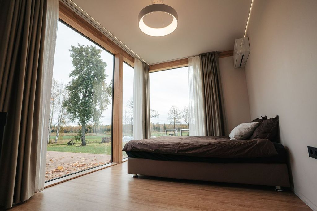 Chambre aménagée dans un module : grande baie et sol en bois.