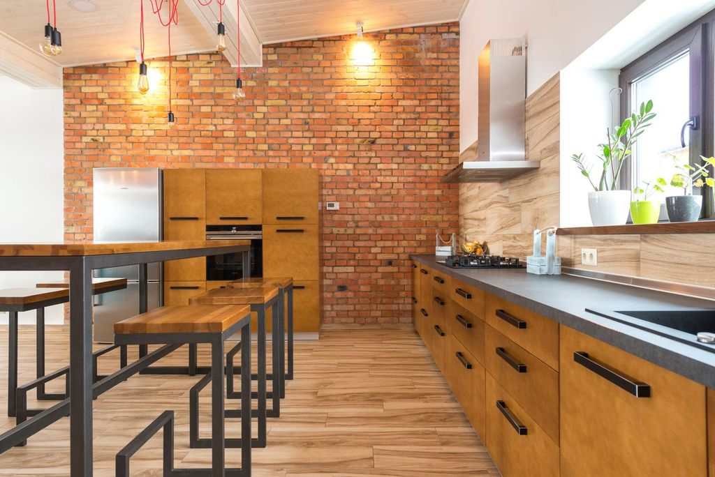 Cuisine sous un mur de brique, avec suspensions d’atelier.