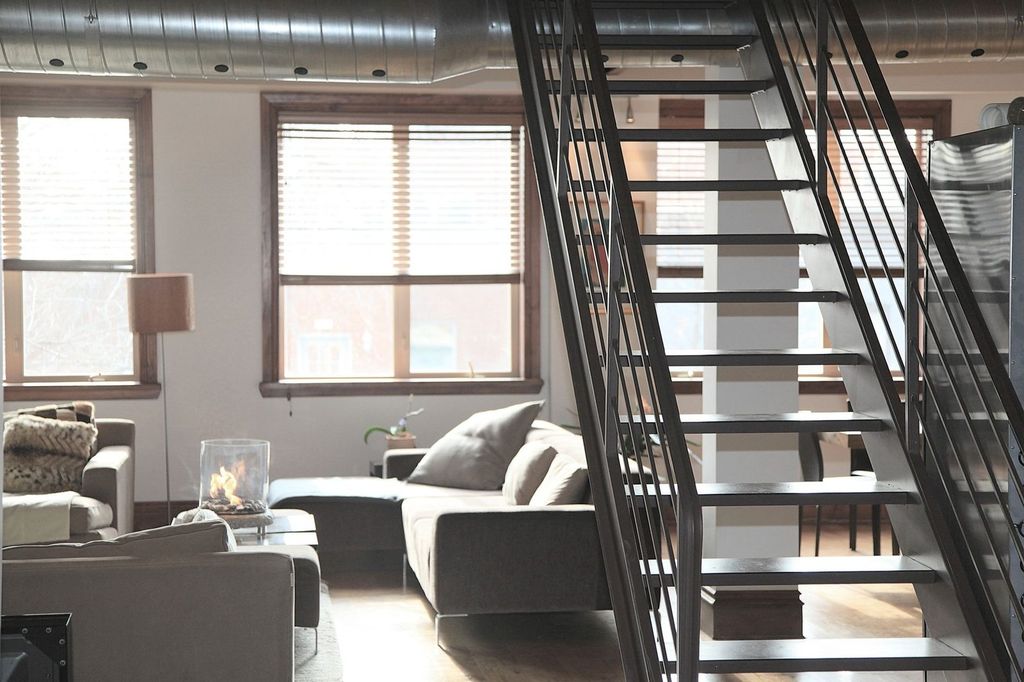 Escalier métallique ouvert : l’accès au niveau haut fait partie du décor.