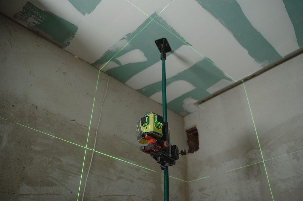 Niveau laser en croix sur un chantier intérieur.