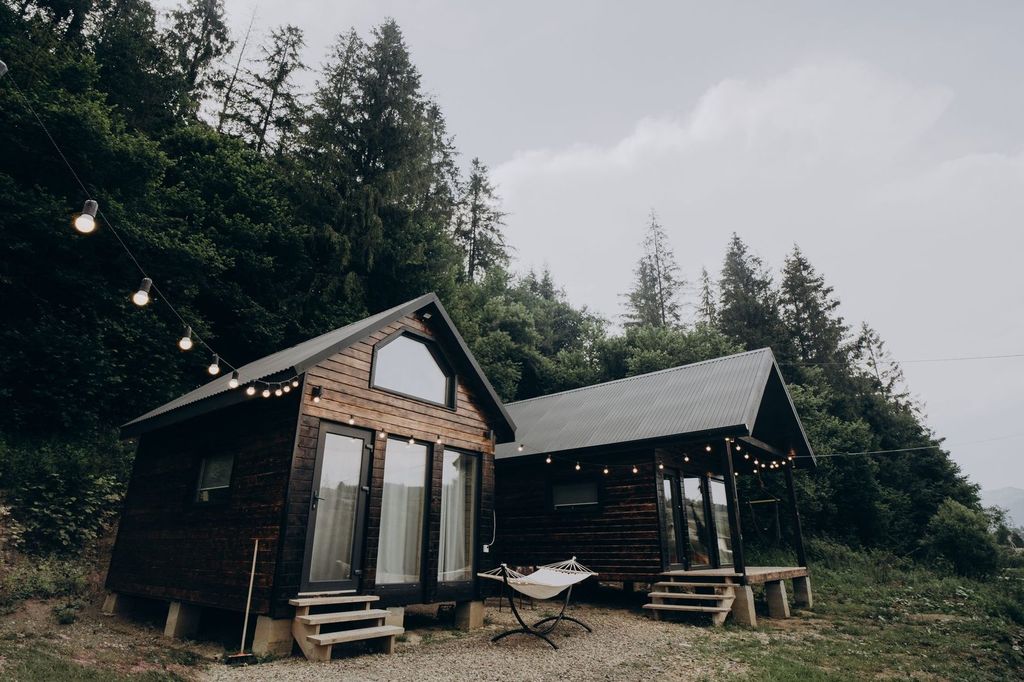 Petites maisons en bois en lisière de forêt.